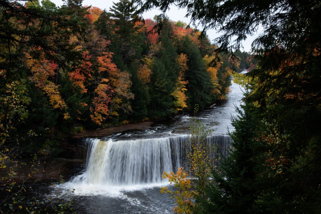 Our Team Scenic view of a waterfall surrounded by autumn foliage in Munising, Michigan.